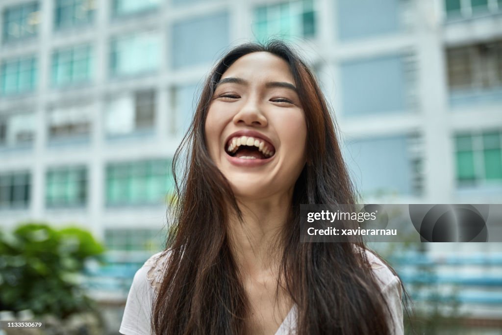 Portrait of smiling young woman at city