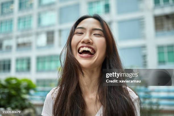 portrait of smiling young woman at city - mulher chinesa imagens e fotografias de stock