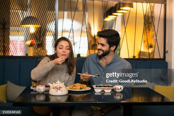young couple eating in a asian restaurant - dinner date stock pictures, royalty-free photos & images