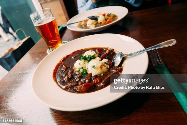 beef stew and pint of beer - irish culture stock-fotos und bilder