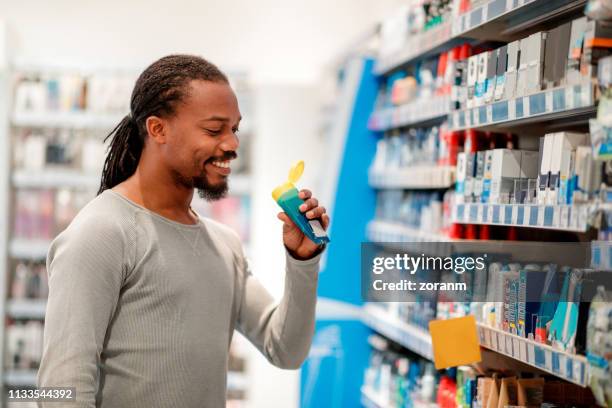 african-american choosing grooming products - aftershave stock pictures, royalty-free photos & images