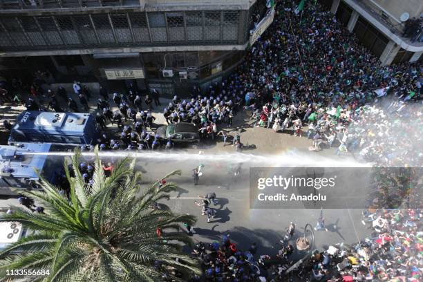 Police officers intervene in protesters as thousands of people stage a demonstration to demand the resignation of Algerian President Abdelaziz...