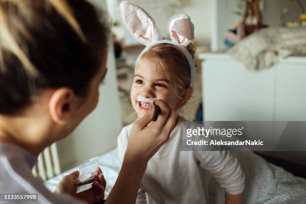 schminken voor little easter bunny - geschminkt gezicht stockfoto's en -beelden