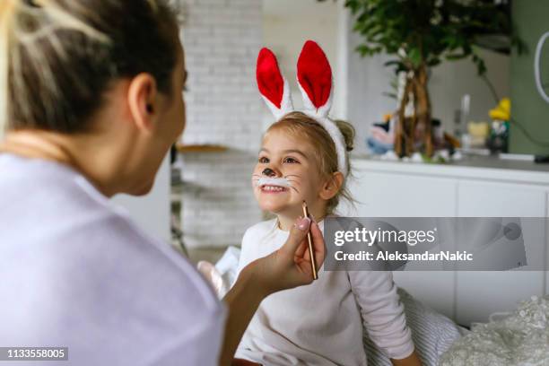 schminken voor little easter bunny - geschminkt gezicht stockfoto's en -beelden