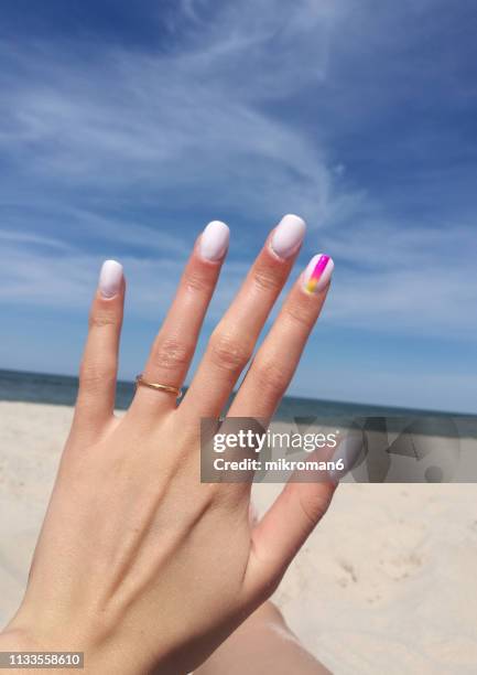 close-up of woman fingers with nail art manicure in white colour - nagelkunst stockfoto's en -beelden