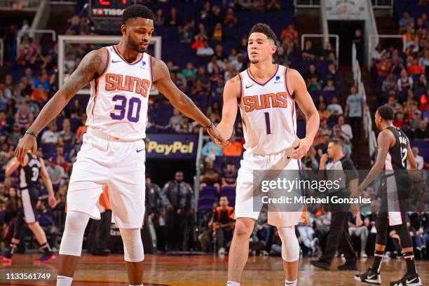 Troy Daniels hi-fives Devin Booker of the Phoenix Suns on March 27, 2019 at Talking Stick Resort Arena in Phoenix, Arizona. NOTE TO USER: User...