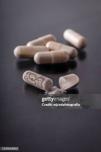 open capsule with scared face. - píldoras stock pictures, royalty-free photos & images