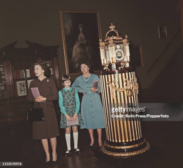 Queen Elizabeth II pictured on left with Princess Margaret, Countess of Snowdon and her daughter Sarah Armstrong-Jones as they stand beside an ornate...