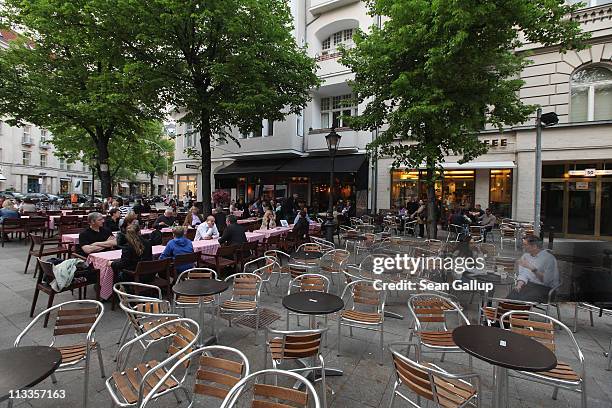 People sit at outdoor restaurants at George Grosz Platz on Kurfuerstendamm avenue on April 27, 2011 in Berlin, Germany. Kurfuerstendamm, known...