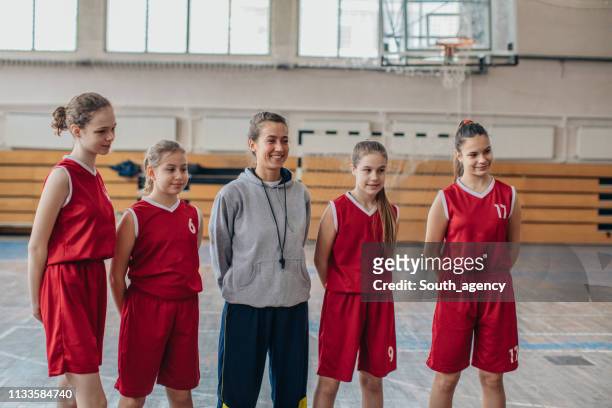 entraîneur de basketball et ses joueurs de filles - hands behind back stock photos et images de collection