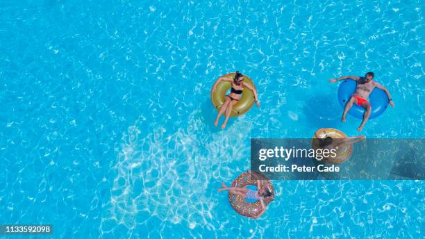 family in pool from the air - man on float stock pictures, royalty-free photos & images