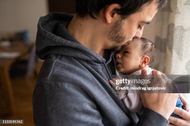 trotse vader zoenen pasgeboren zoon - father and baby stockfoto's en -beelden