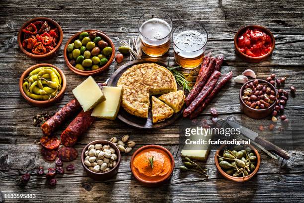 tapas and beer: typical spanish food shot on rustic wooden table - beer nuts stock pictures, royalty-free photos & images