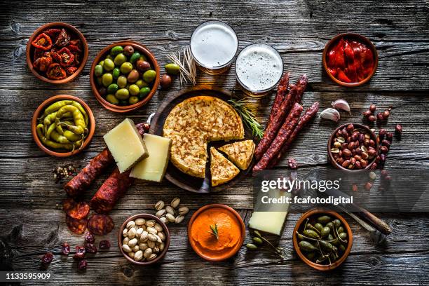 tapas e birra: tipico cibo spagnolo girato dall'alto su un tavolo rustico in legno - cultura spagnola foto e immagini stock