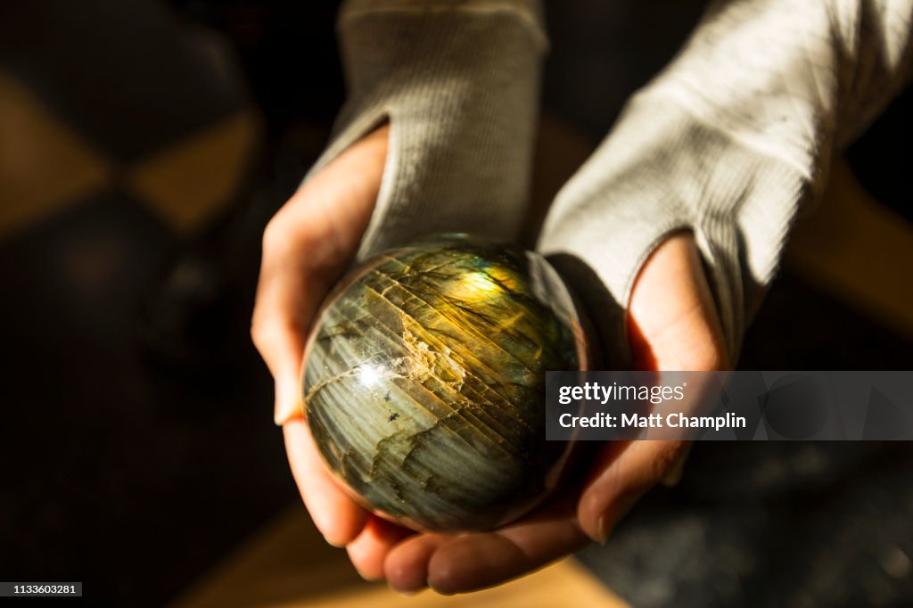 Woman's Hands Holding Labradorite Rock Sphere