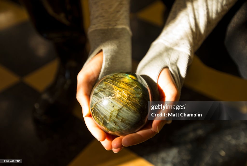 Woman's Hands Holding Labradorite Rock Sphere