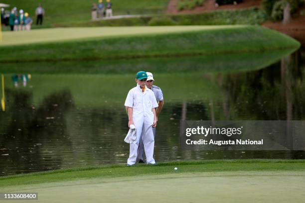 Winner Kevin Streelman and his caddie Ethan Couch read No. 9 during the Par 3 Contest for the Masters at Augusta National on Wednesday, April 8, 2015.