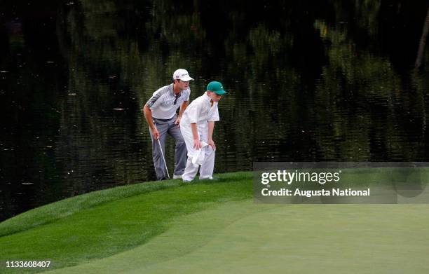 Kevin Streelman and his caddie Ethan Couch line up a putt on the No. 9 to win in a playoff during the Par 3 Contest for the Masters at Augusta...