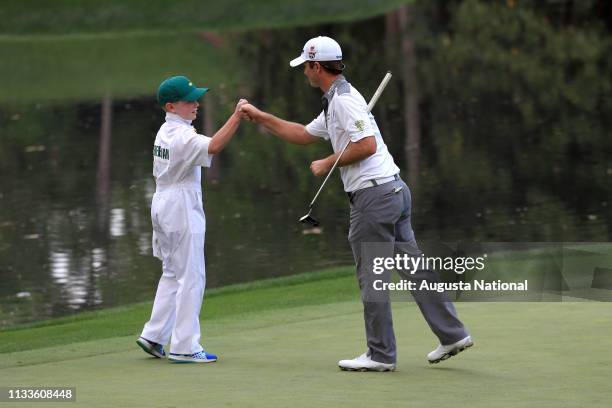 Kevin Streelman celebrates with his caddie Ethan Couch after Streelman made a putt to win the he Par 3 Contest for the Masters at Augusta National on...