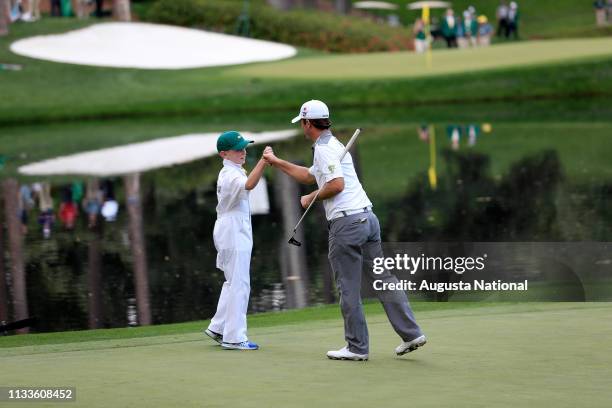 Winner Kevin Streelman and his caddie Ethan Couch bump fists on No. 9 during the Par 3 Contest for the Masters at Augusta National on Wednesday,...