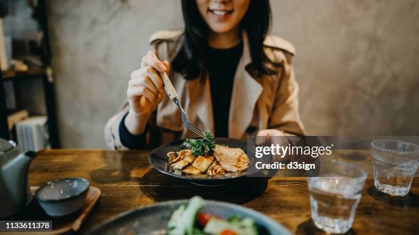 smiling young woman enjoying dinner date with friends in a restaurant - people eating in bistro stockfoto's en -beelden