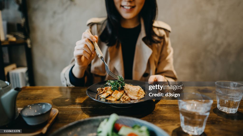 Smiling young woman enjoying dinner date with friends in a restaurant