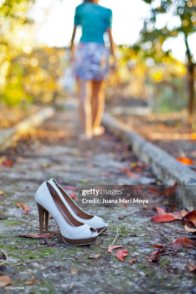 Outdoor heeled shoes in autumn and barefoot girl in the background.  Spain