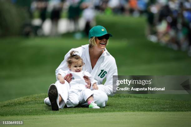 Angie Watson, wife of Masters Champion Bubba Watson, and his daughter Dakota laugh during the Par 3 Contest at Augusta National Golf Club on...