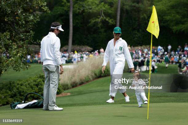 Masters champion Bubba Watson watches his daughter Dakota walk with his wife Angie during the Par 3 Contest at Augusta National Golf Club on...