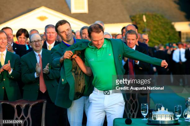 Masters champion Jordan Spieth presents Danny Willett of England the Green Jacket after Willett posted a total score of 5-under-par 283 to win the...