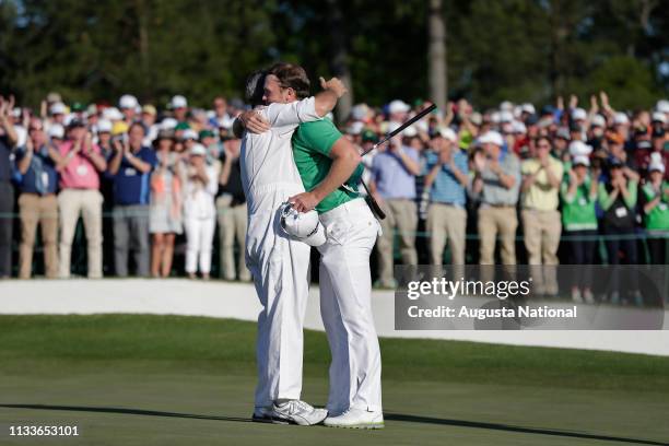 Danny Willett of England hugs his caddie Jonathan Smart after holing out on No. 18 during the final round at Augusta National Golf Club on Sunday...