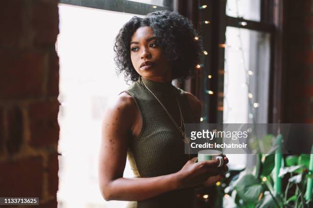 Young woman drinking coffee in her Downtown Los Angeles apartment