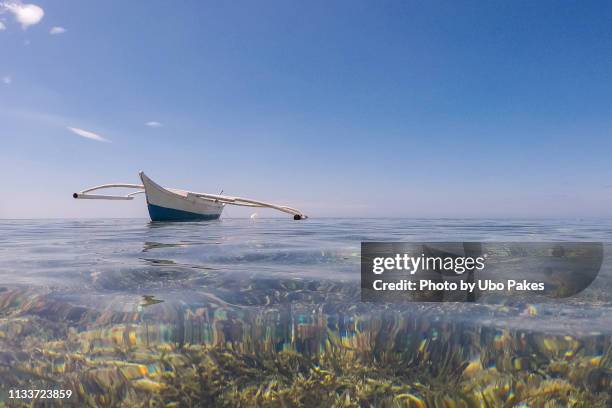 small outrigger boat on shallow water - outrigger stock pictures, royalty-free photos & images