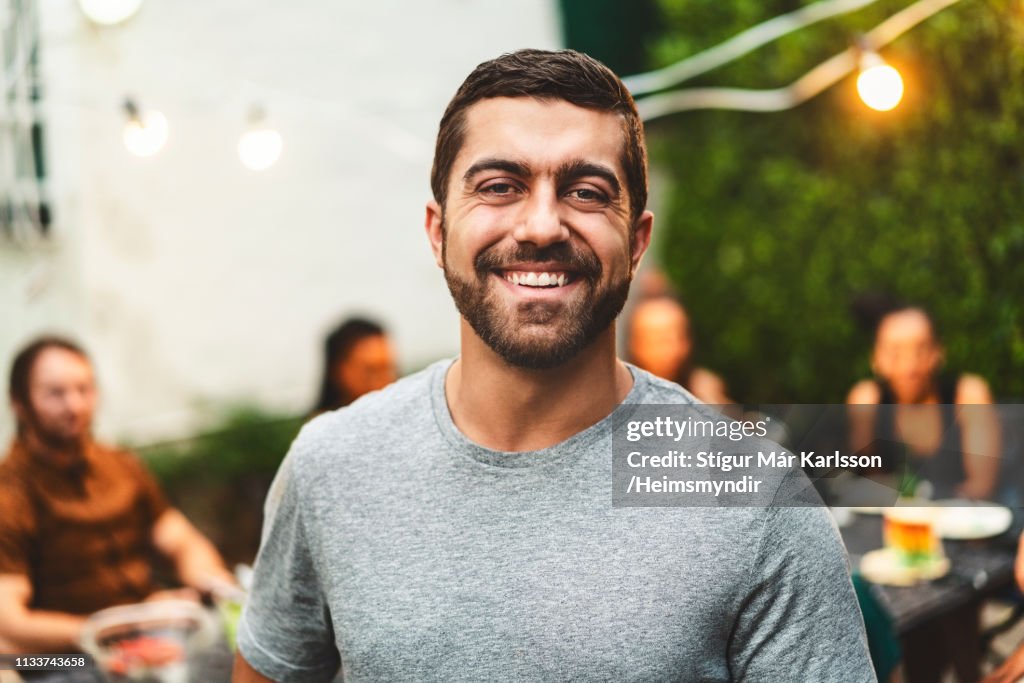 Portrait of cheerful bearded man in yard