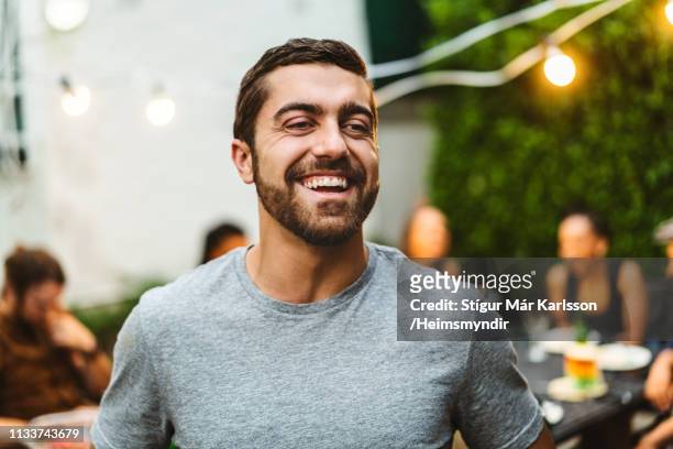 man enjoying garden party with friends in yard - man 30s stock pictures, royalty-free photos & images