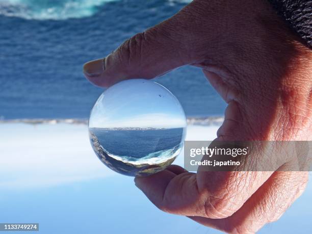 seascape through a crystal ball - mano umana stock pictures, royalty-free photos & images