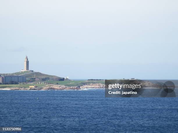 view of the tower of hercules and the bay of la coruña - olas rompientes stock-fotos und bilder