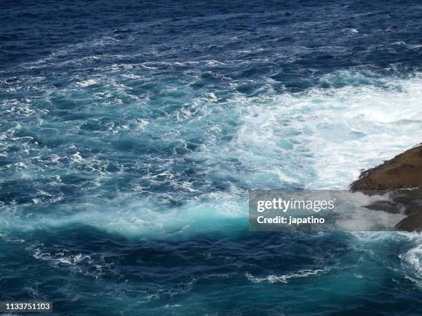 waves breaking against the rocks - fuerzas de la naturaleza stock pictures, royalty-free photos & images