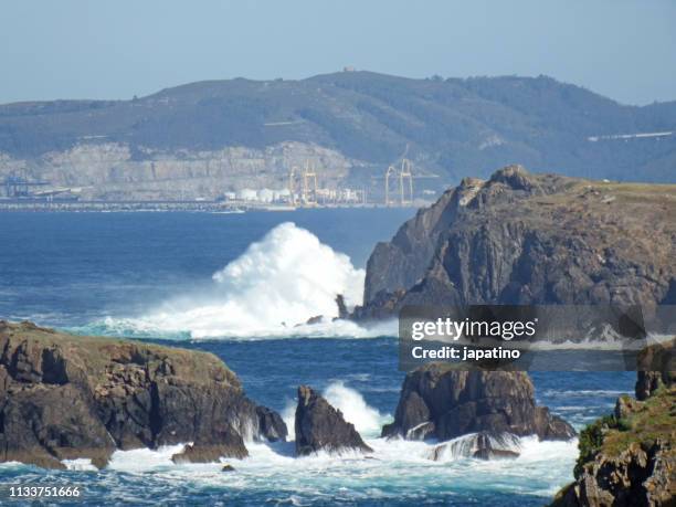 waves breaking against the rocks - olas rompientes stock-fotos und bilder