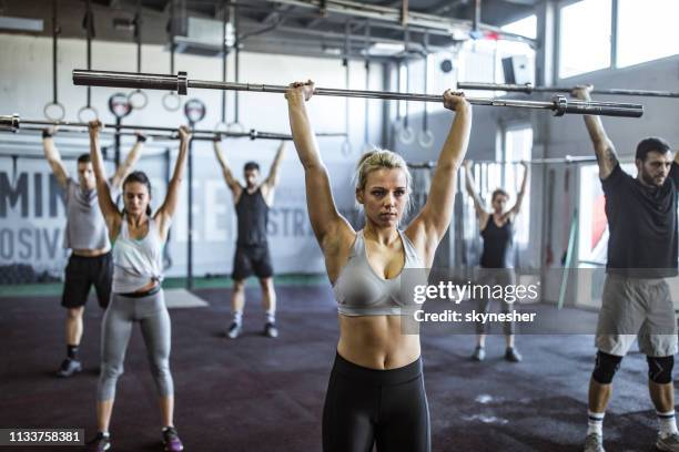 grote groep jonge atleten met een gewicht opleiding in een sportschool. - snatch weightlifting stockfoto's en -beelden