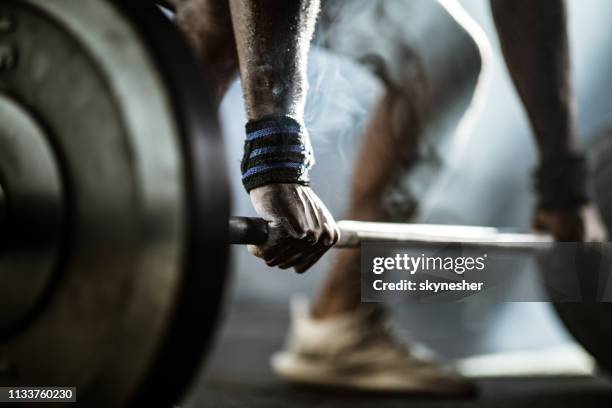 fermez-vous vers le haut de la main de l'homme pendant le deadlift. - entraînement-aux-haltères photos et images de collection