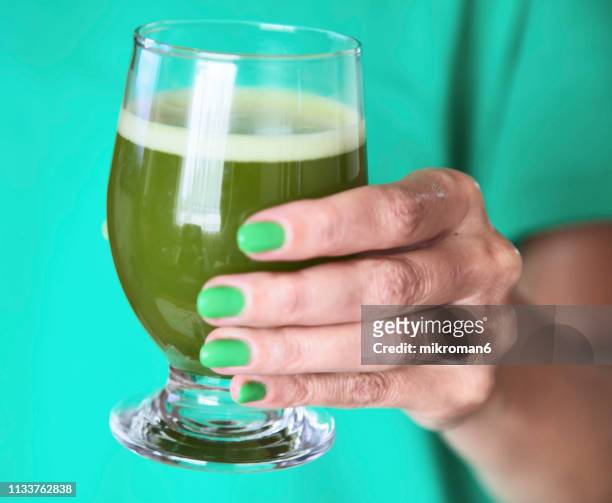 hand of woman holding a glass of japanese powdered green tea - green nail polish stock pictures, royalty-free photos & images