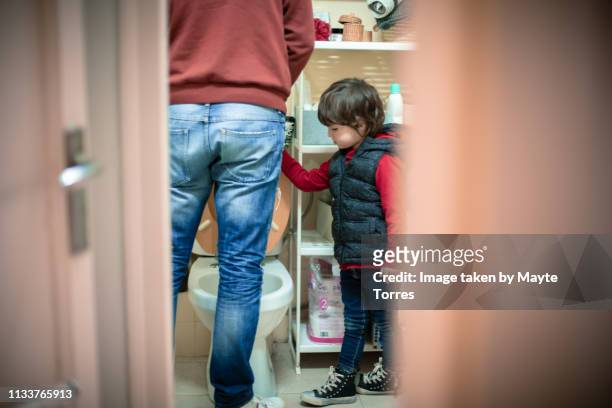 toddler looking how dad is peeing - child urinating stockfoto's en -beelden