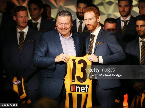 Conor Glass of the Hawks accepts his jumper from Paul Dear during the Hawthorn Hawks AFL season launch at Melbourne Cricket Ground on March 05, 2019...