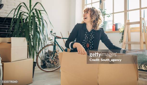 lady packt kisten in neuer wohnung aus - man boxes moving home stock-fotos und bilder