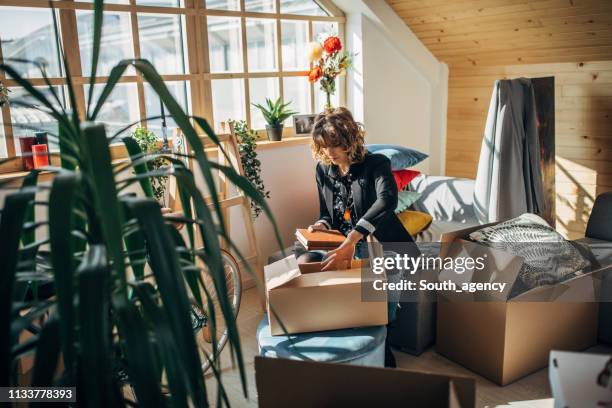 woman unpacking boxes in new home - beautiful mess home stock pictures, royalty-free photos & images