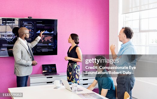 Businessman using graphs on screen in business meeting Businessman using graphs on screen in business meeting
