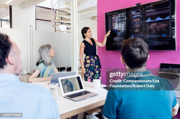 businesswoman using graphs on screen in business meeting - técnica ilustrativa - fotografias e filmes do acervo