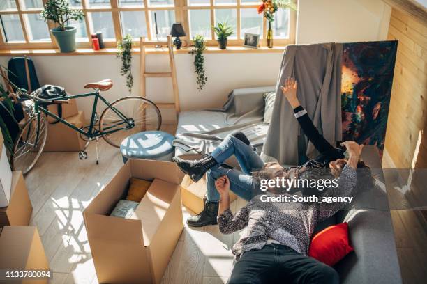 young couple relaxing on sofa in new apartment - messy boyfriend stock pictures, royalty-free photos & images