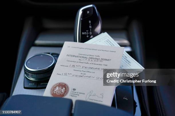 In this photo illustration an International Driving Permit and an International Motor Insurance Certifcate, known as a 'green card' sit inside a car...